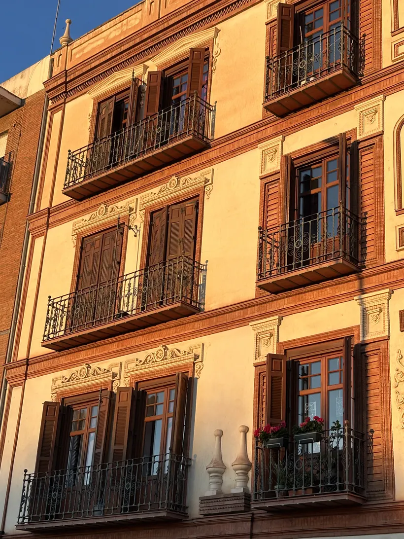 Sonnenbeschienene Häuserfassade mit Balkonen in der Altstadt von Málaga