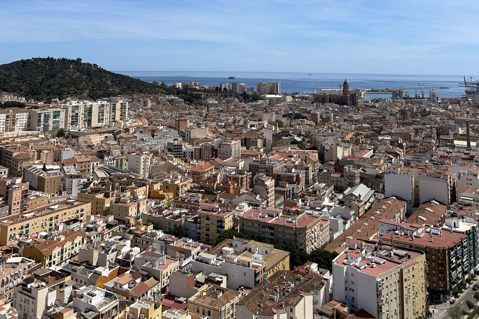 Blick über die roten Dächer der Altstadt von Málaga mit Kathedrale, Hafen und Mittelmeer